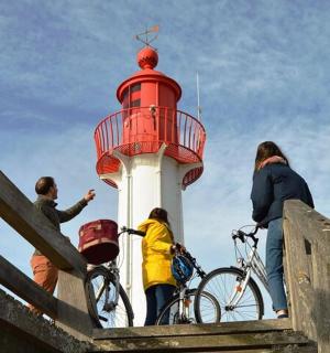 a group of people standing around a lighthouse