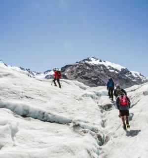 a group of people walking on a snow covered mountain