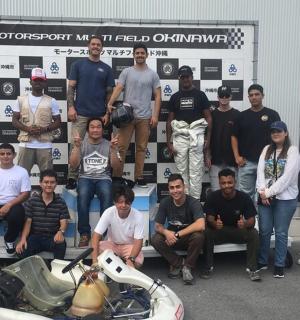 a group of people posing for a picture next to a motorcycle