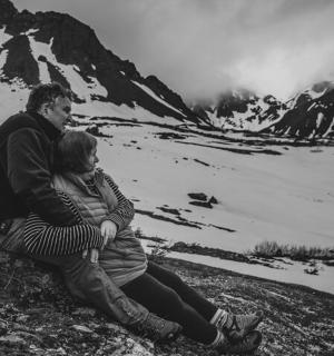 muž a žena sedící na vrcholu hory