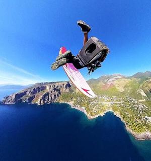 osoba předvádějící trik na snowboardu ve vzduchu