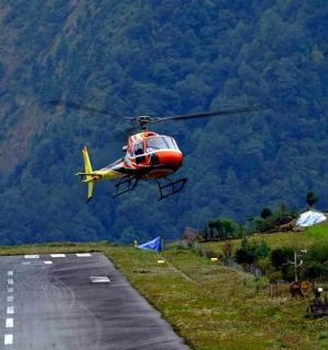 一架红黄色的直升机飞过跑道