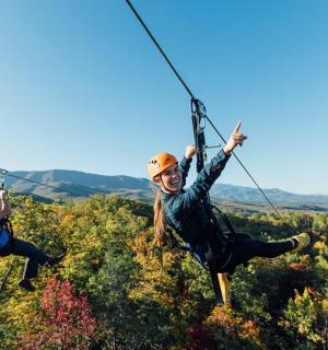 dva lidé na zip line v horách