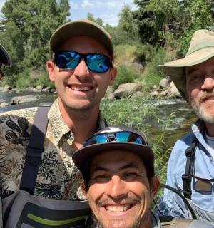 四个男人在河边摆姿势拍照