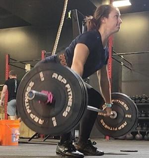 一名女子在健身房举起杠铃