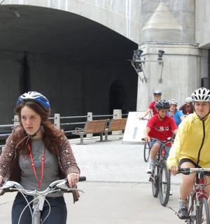 a group of people riding bikes down a sidewalk