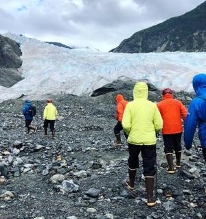 skupina lidí kráčejících před ledovcem