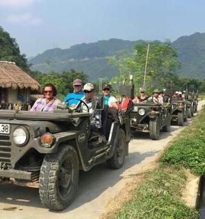 一群人开着吉普车沿着道路行驶