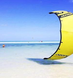 一个人站在海滩上，带着风筝