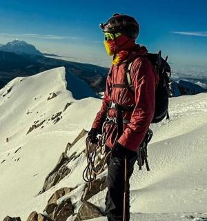 一名男子站在白雪皑皑的山顶上