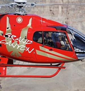 a red helicopter is flying in the air