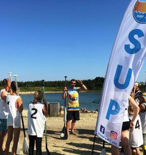 skupina lidí stojících na pláži s vlajkou