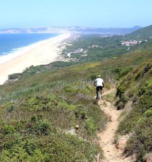 一个人在海滩附近的山上骑自行车
