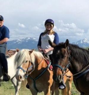 a group of people riding horses in a field