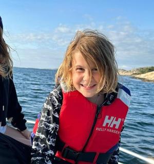 Dvě mladé dívky na lodi ve vodě s majákem