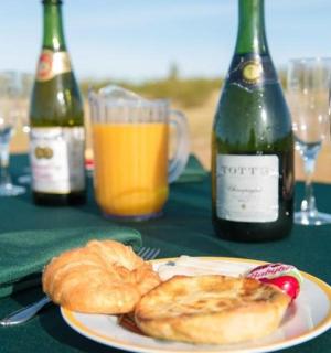 a table with a plate of food and bottles of wine