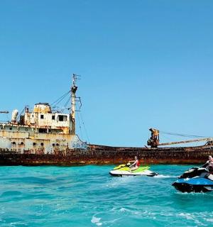 一艘旧船在水中，两个人乘坐信息器