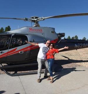 two people standing in front of a helicopter
