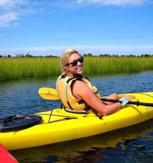 una donna in un kayak giallo sull'acqua