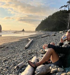 一名男子坐在海滩上打电话