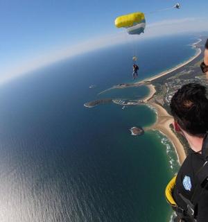 two people flying a parachute over a body of water