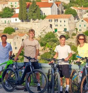 um grupo de pessoas em pé com suas bicicletas em uma ponte