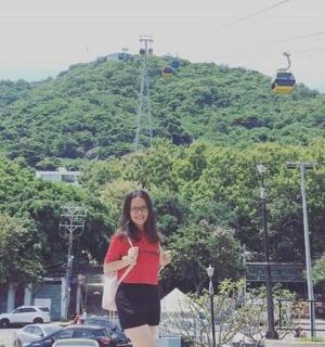 一位女士站在有滑雪缆车的公园前