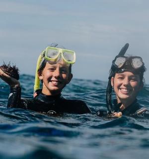 两个人在水中，头上戴着护目镜