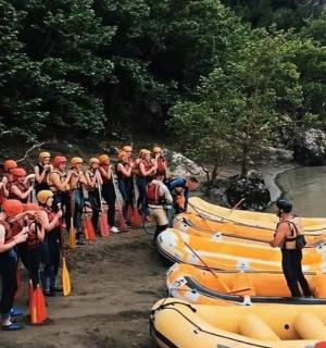 a group of people standing next to rafts on a river