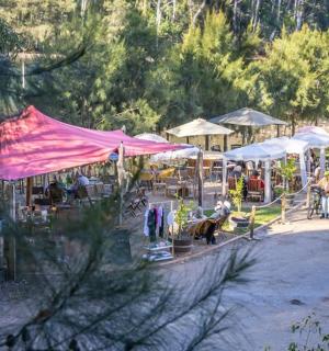 湖边的一组帐篷,帐篷下坐着一些人