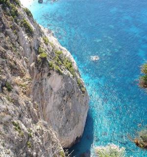 an aerial view of the blue water on a cliff