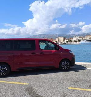 uma van vermelha estacionada em um estacionamento próximo à água