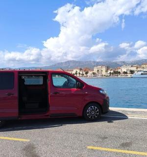 uma van vermelha estacionada em um estacionamento próximo à água