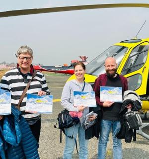 a group of people standing in front of a helicopter
