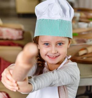 戴着厨师帽的小女孩竖起了大拇指