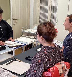 a man and two women sitting at a table in a room
