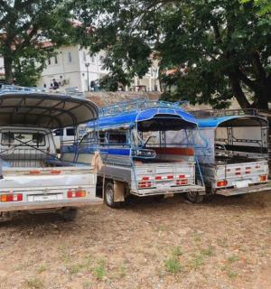 two buses parked next to each other on a field