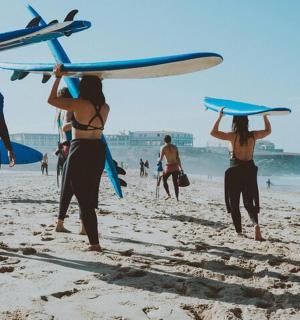 a group of people holding surfboards on a beach