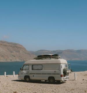 a white van parked next to a body of water
