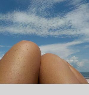 osoba sedící na pláži se zkříženýma nohama