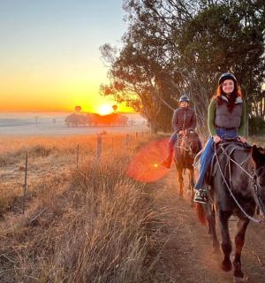 日落时分，两个人骑马沿着土路前行