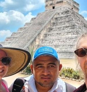a group of people standing in front of the pyramid