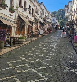 a cobblestone street with tables and chairs and buildings