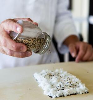 a person holding a jar of rice on a table