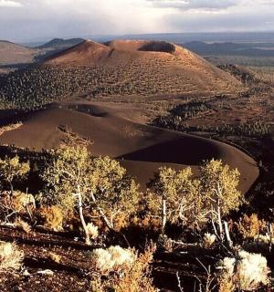 an aerial view of a mountain with trees and hills