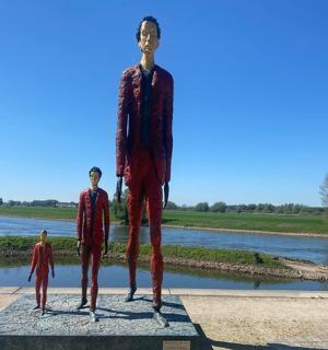 三个男人站在河边的雕像