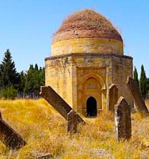 田野里有一栋老建筑,旁边还有一座墓地