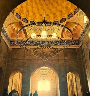 清真寺里的枝形吊灯周围有人走动