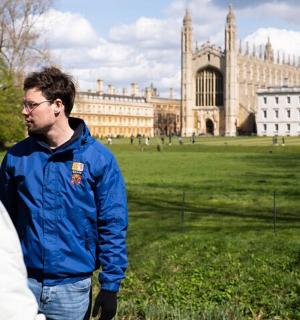 two men standing in a field in front of a building