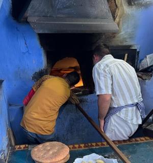 two people are looking into a hole in a kitchen